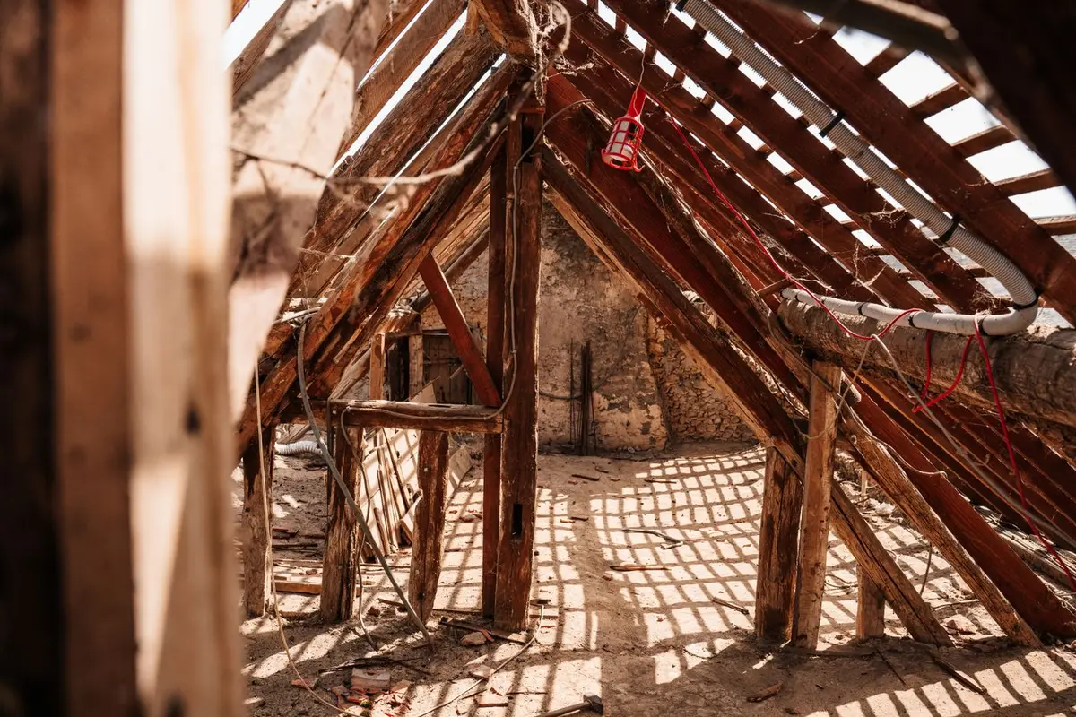 Freigelegter Dachstuhl mit alten Holzbalken vor der Sanierung