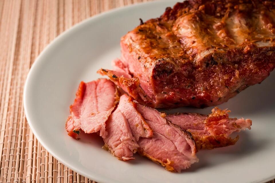 Saftiger Braten mit Kruste, aufgeschnitten auf einem weißen Teller