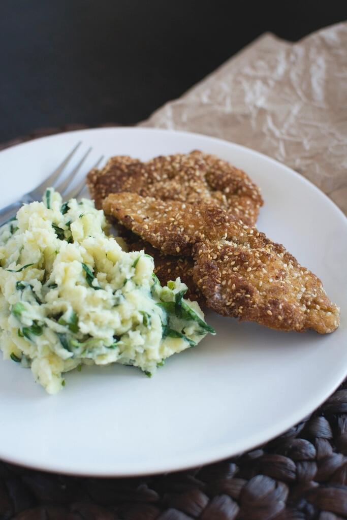 Goldbraun gebackenes Schnitzel mit Erdäpfelsalat auf weißem Teller