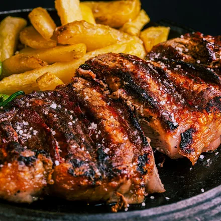 Gegrilltes Steak mit Rustikal-Pommes und Pimientos