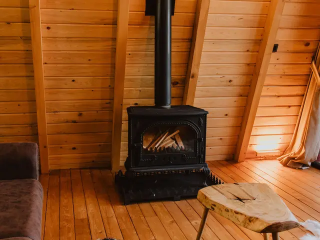 Dachgeschoß aus Holz mit Kaminofen, Fell am Boden und kleinem Holztisch
