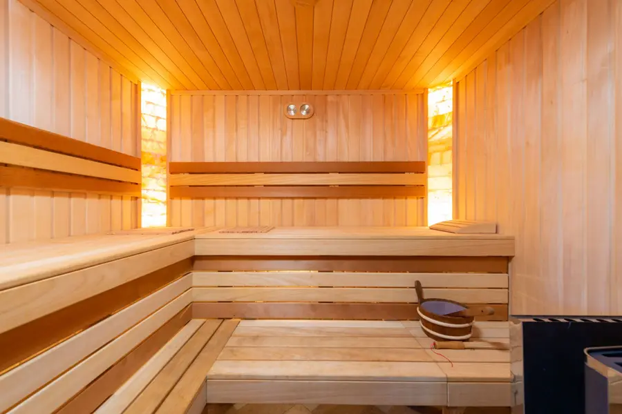 Finnische Sauna aus hellem Holz mit warmem Licht